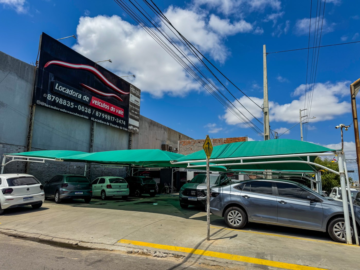 Fachada da Locadora do Vale com o pátio coberto e carros estacionados